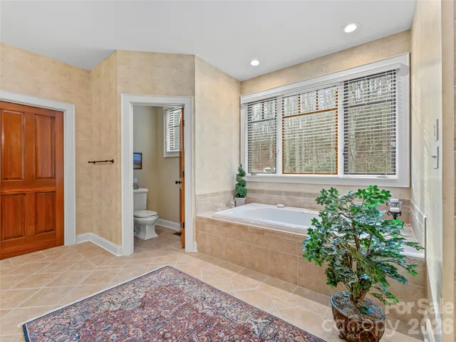 a bedroom with a bed and dresser with mirror