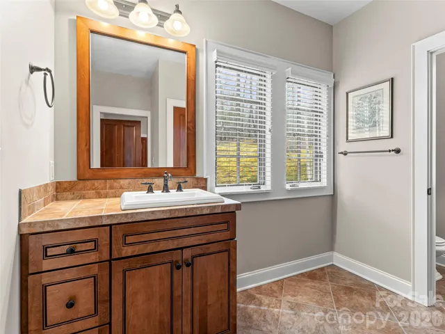 a view of an empty room with window and a ceiling fan