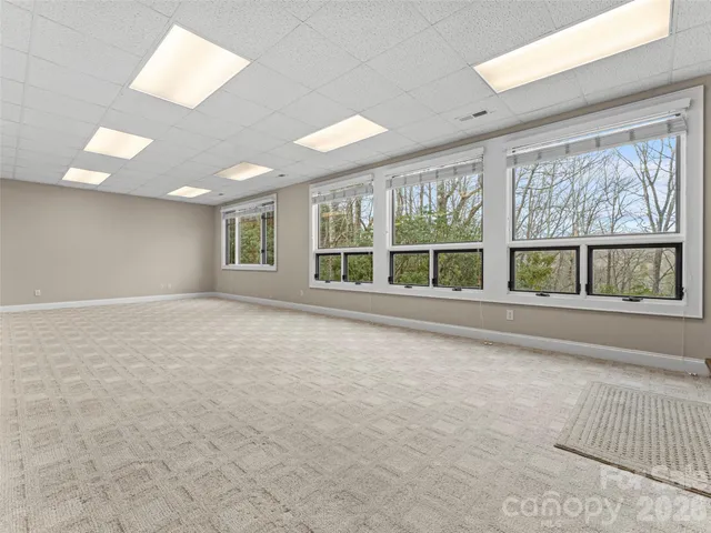 a big room with windows and a fireplace