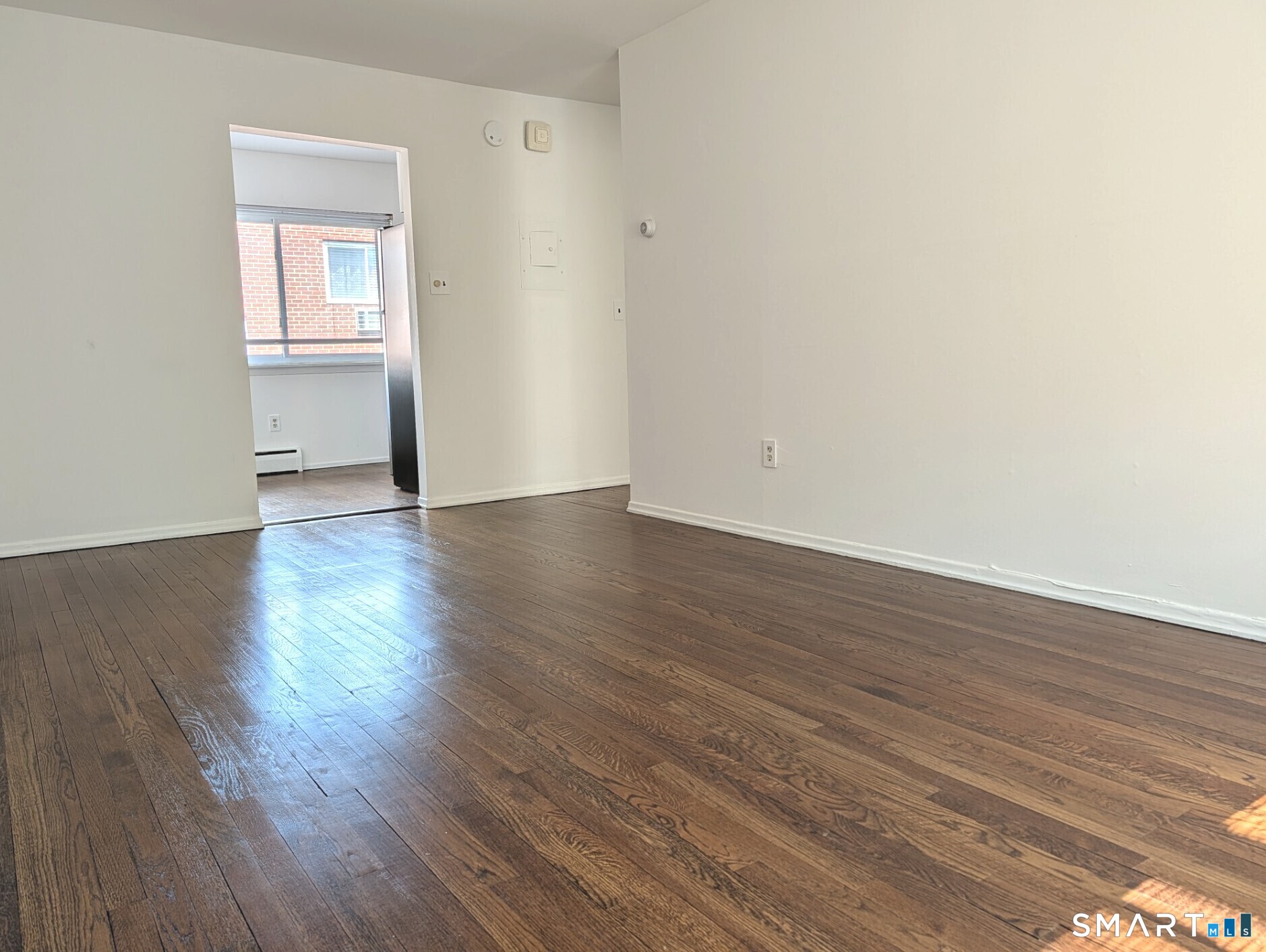 18 Prospect Street, Unit C10 Norwalk, CT 06850 - Photo 4 of 11 a view of an empty room with wooden floor and a window