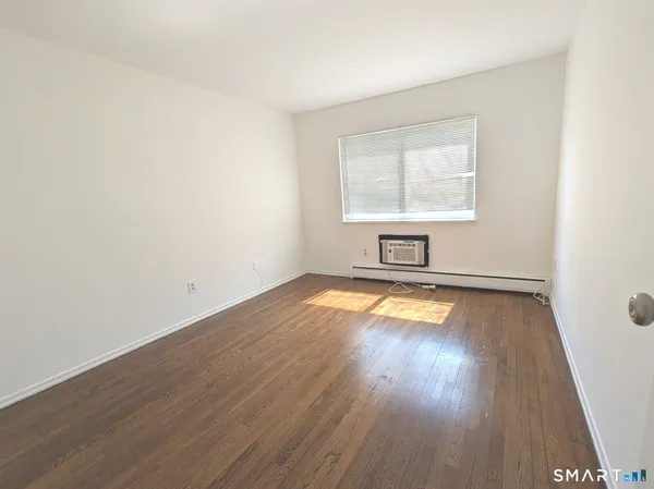 a view of a room with wooden floor and white walls