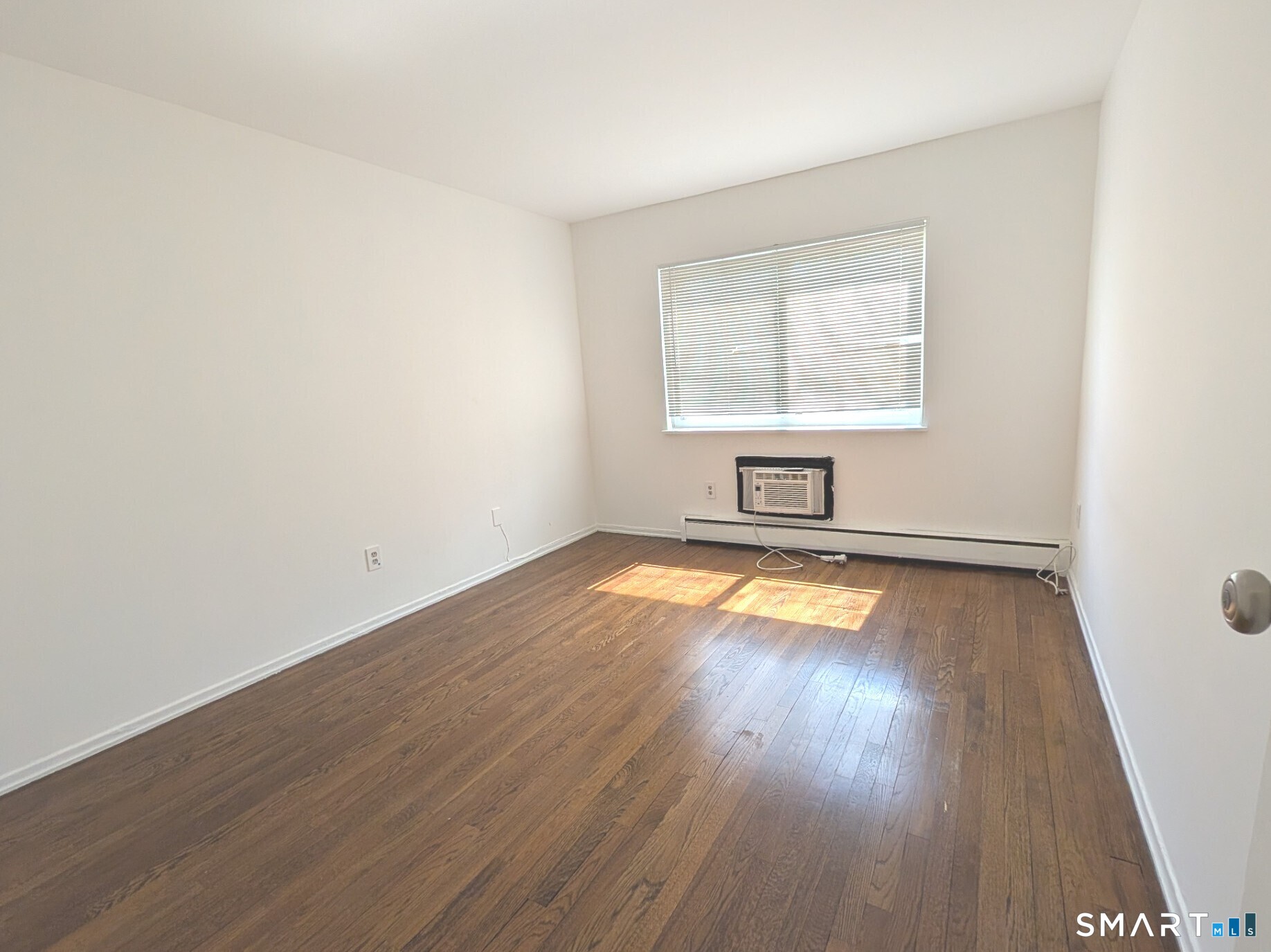18 Prospect Street, Unit C10 Norwalk, CT 06850 - Photo 8 of 11 an empty room with wooden floor and windows