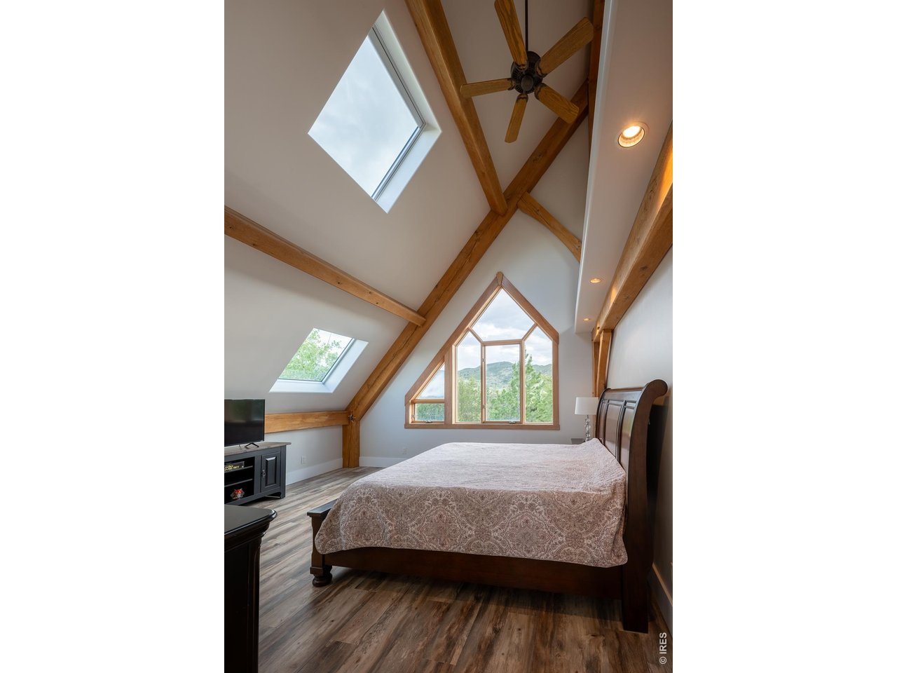 4099 Michaud Lane Fort Collins, CO 80521 - Photo 11 of 50 The peaceful primary suite is where relaxation meets the outdoors, featuring a custom picture window framed in beautiful white oak that showcases serene views and highlights the exquisite wood craftsmanship found throughout the home.