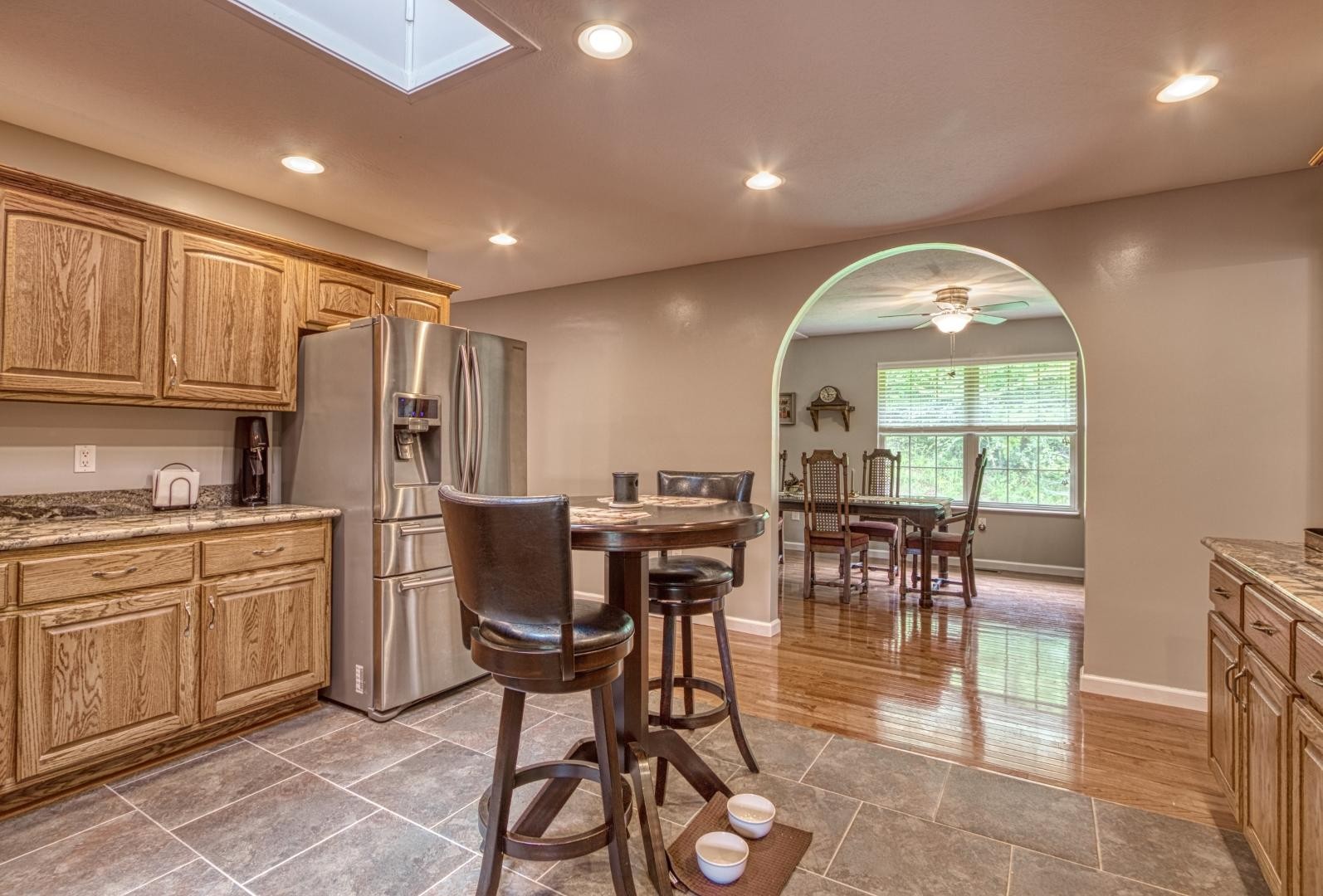 720 Rock House Road Kodak, TN 37764 - Photo 6 of 18 a kitchen with stainless steel appliances granite countertop a stove a sink a refrigerator with a dining table and chairs