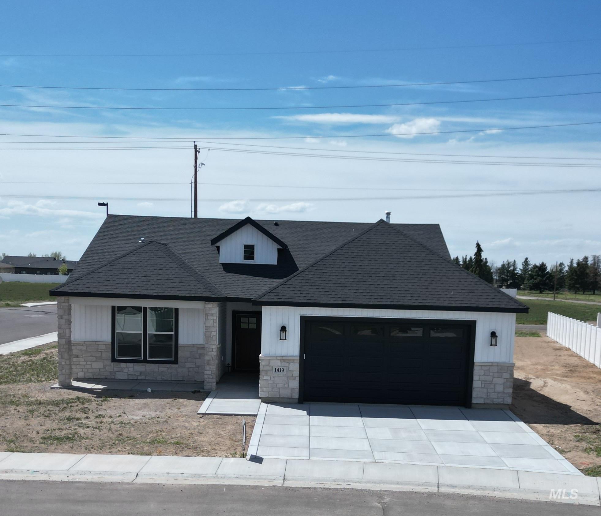 Contemporary-style residence featuring a dark asphalt shingle roof and a prominent front-facing dormer