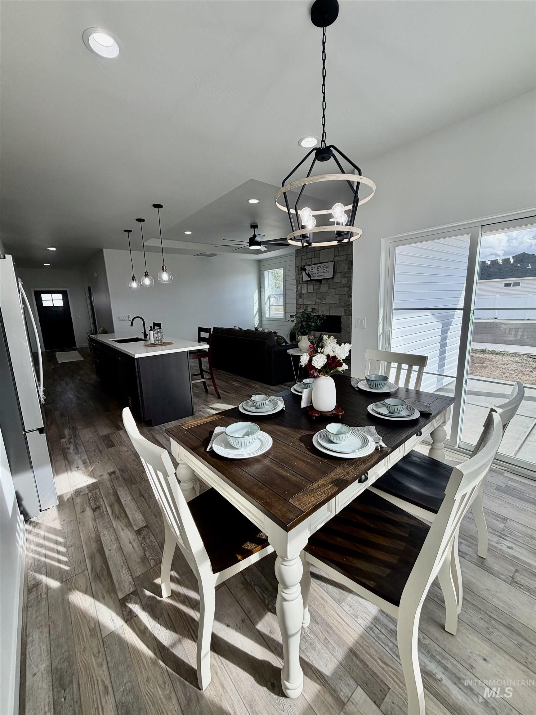 1419 Topaz Rupert, ID 83350 - Photo 9 of 41 Dining room featuring suspended lighting, a ceiling fan, dark wood finished floors, and a fireplace