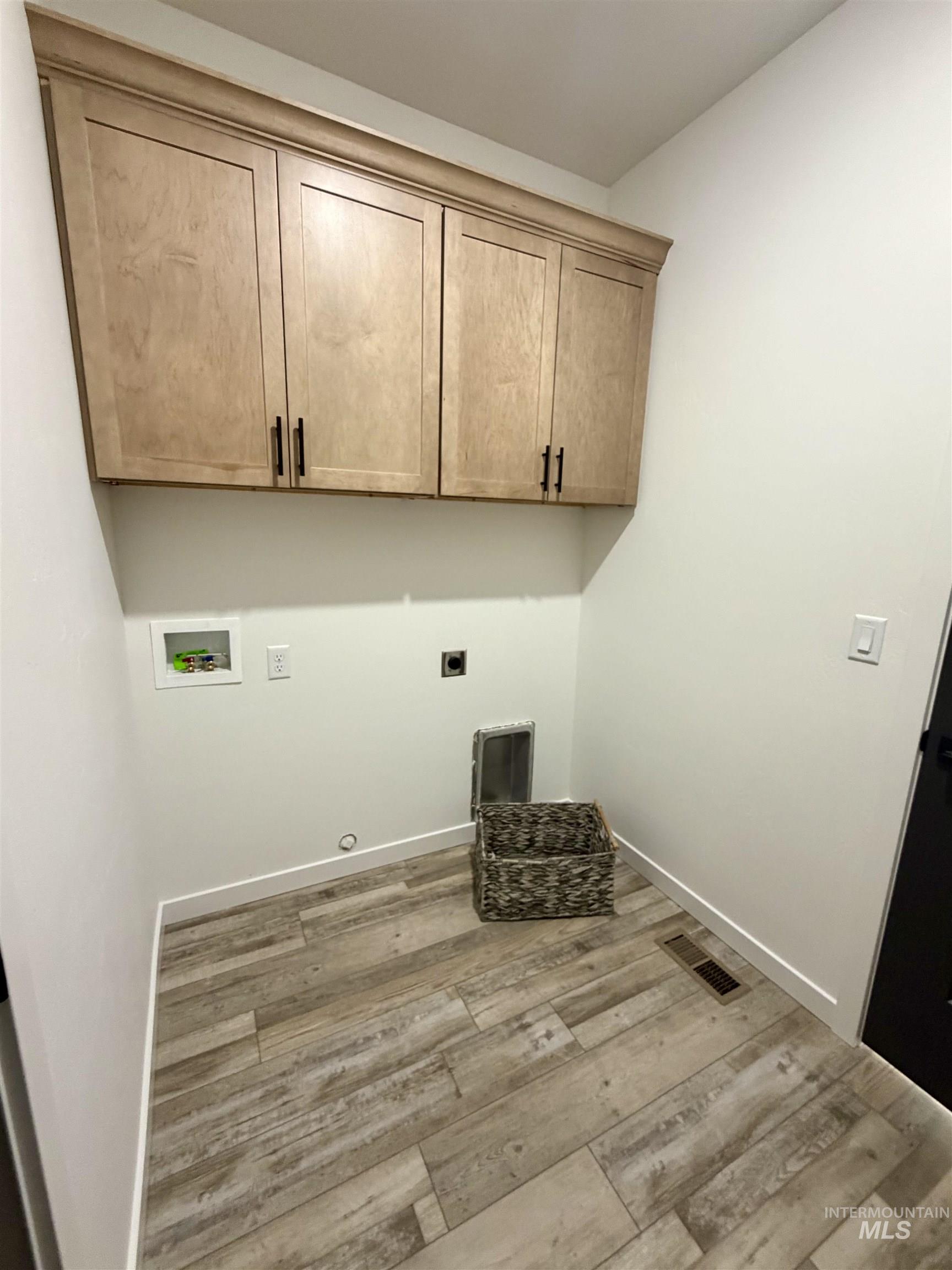 1419 Topaz Rupert, ID 83350 - Photo 15 of 41 Laundry area featuring light wood-style flooring, cabinet space, hookup for an electric dryer, and hookup for a washing machine