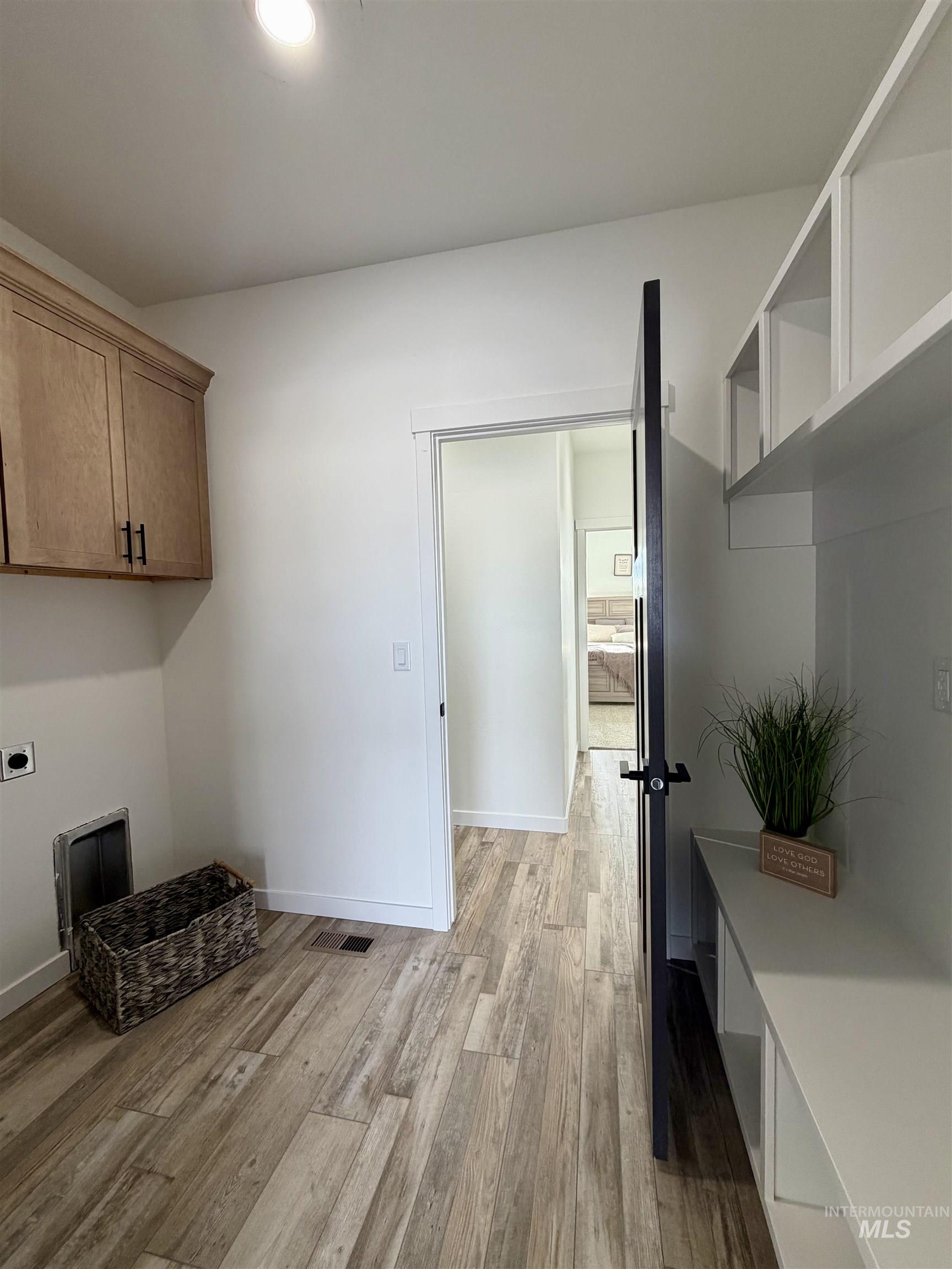 1419 Topaz Rupert, ID 83350 - Photo 17 of 41 Laundry area featuring light wood-style flooring, hookup for an electric dryer, and cabinet space