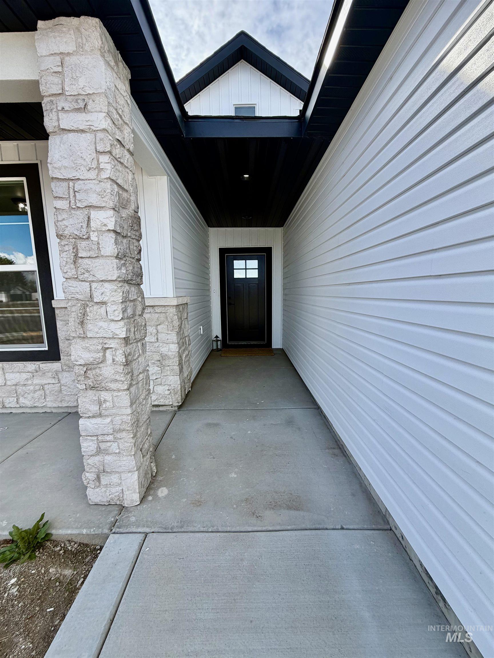 1419 Topaz Rupert, ID 83350 - Photo 2 of 39 Covered entry with stone-clad columns and a dark paneled ceiling