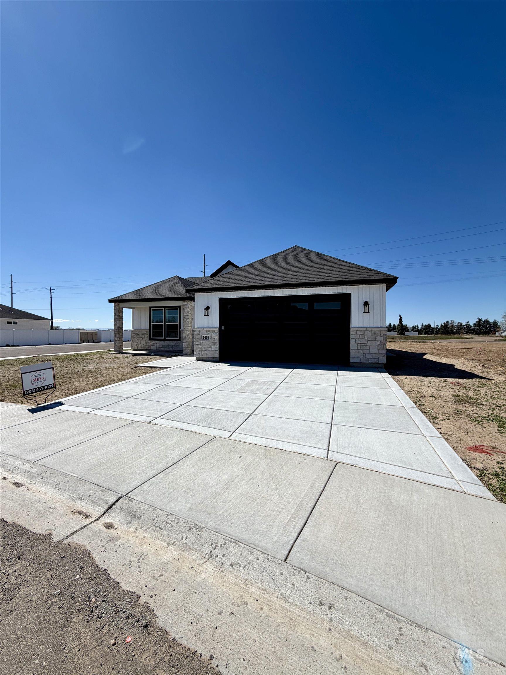 1419 Topaz Rupert, ID 83350 - Photo 34 of 41 View of front of property featuring stone siding, a garage, driveway, and a shingled roof