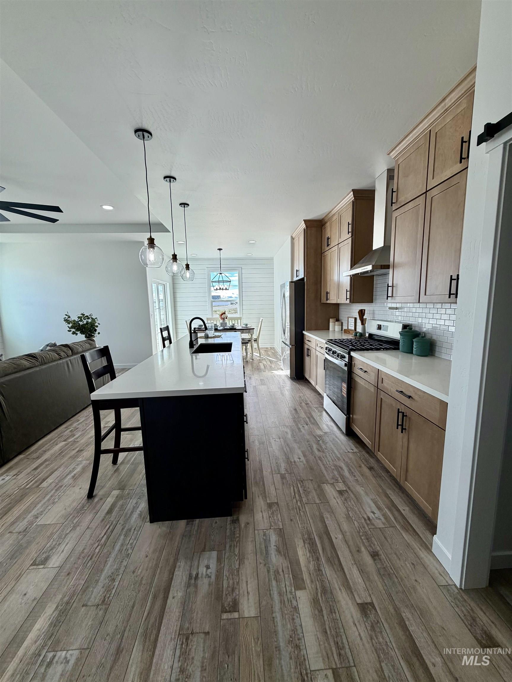 1419 Topaz Rupert, ID 83350 - Photo 38 of 41 Kitchen featuring open floor plan, stainless steel appliances, a kitchen island with sink, a kitchen breakfast bar, and tasteful backsplash
