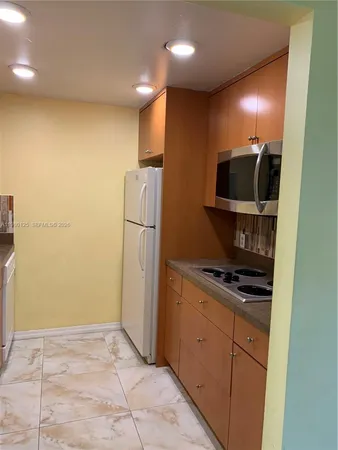 a kitchen with a refrigerator and a stove