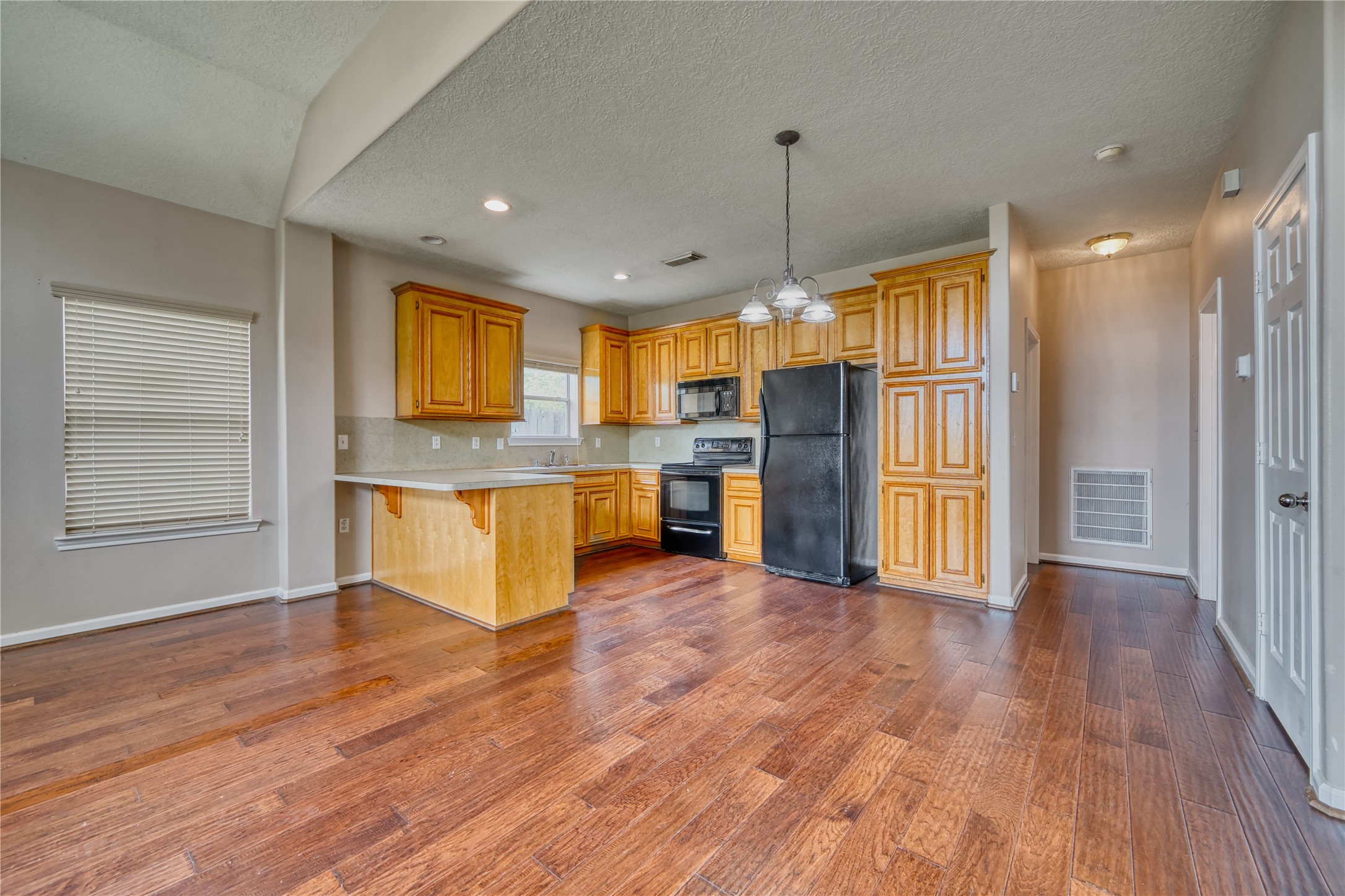 770 Hunt Road, Unit 314 Baytown, TX 77521 - Photo 10 of 26 a large kitchen with a center island wooden floor stainless steel appliances and cabinets