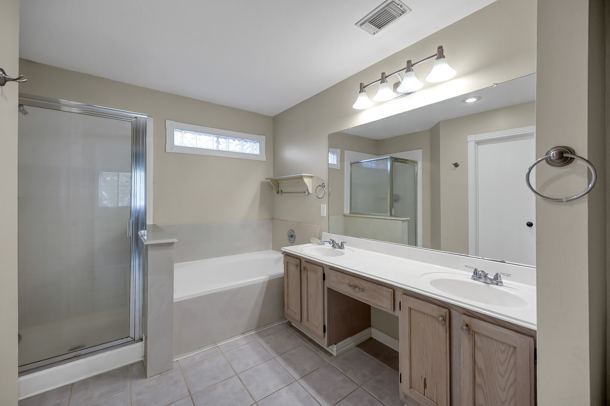 222 Lazy Lane Montgomery, TX 77356 - Photo 11 of 18 a bathroom with a tub a sink double vanity and a mirror