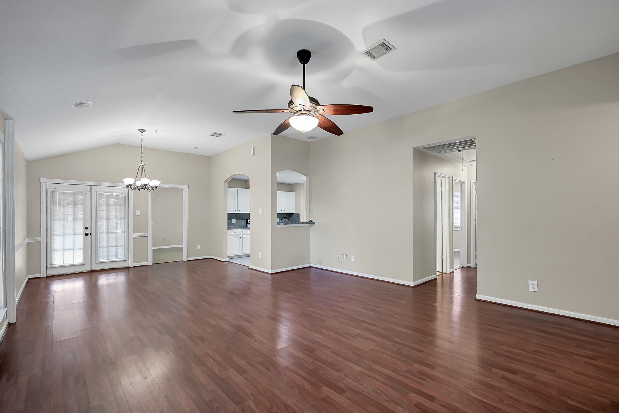 222 Lazy Lane Montgomery, TX 77356 - Photo 4 of 18 a view of an empty room with wooden floor ceiling fan and kitchen view
