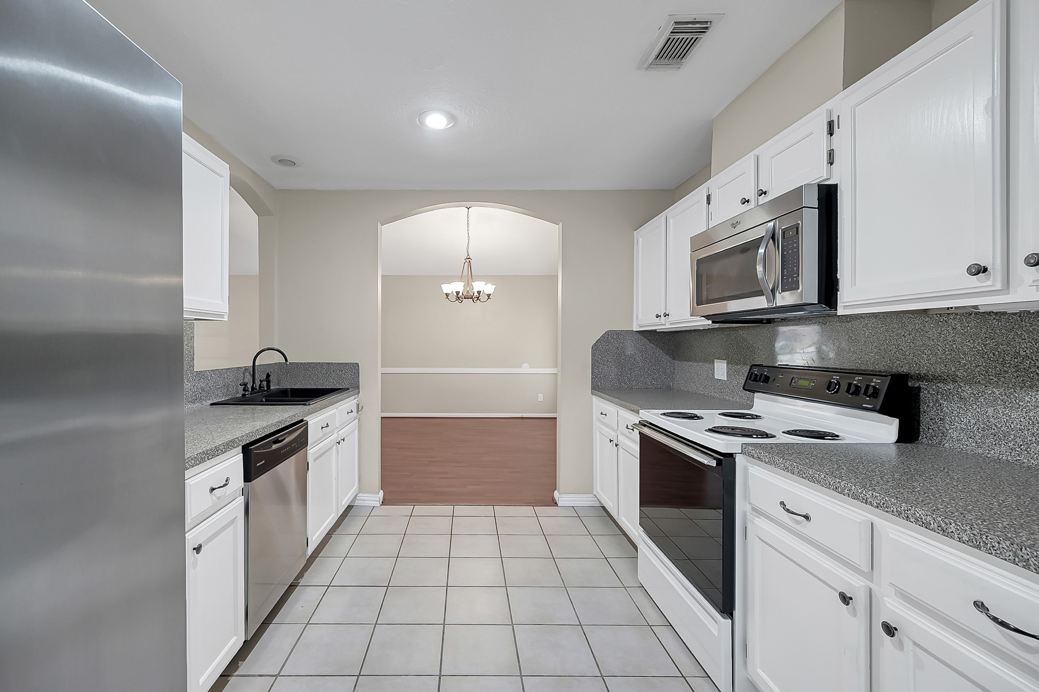 222 Lazy Lane Montgomery, TX 77356 - Photo 8 of 18 a kitchen with stainless steel appliances granite countertop a stove top oven a sink a counter space and cabinets