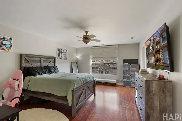 a bedroom with a bed and wooden floor