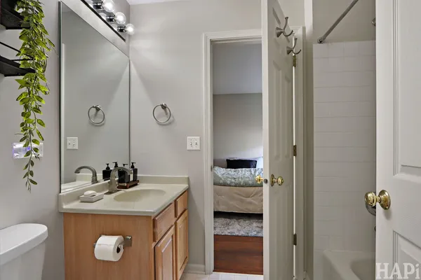 a en suite bathroom with a granite countertop sink and a mirror