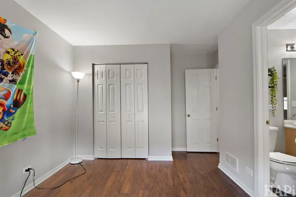 an empty room with wooden floor and a potted plant
