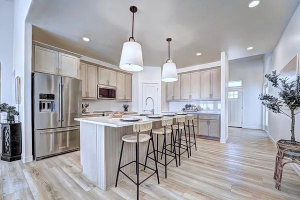 a kitchen with kitchen island a refrigerator a stove a center island and wooden floor