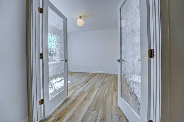 a view of a hallway with wooden floor and a livingroom view