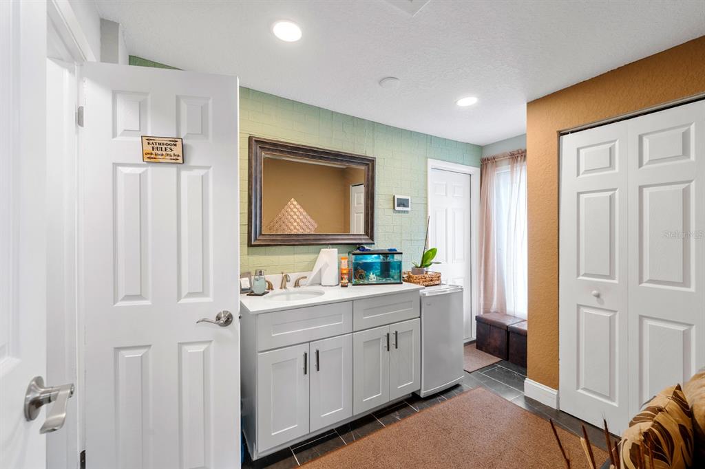 2152 Arcadia Road Holiday, FL 34690 - Photo 13 of 30 a bathroom with a double vanity sink a mirror a vanity and a shower
