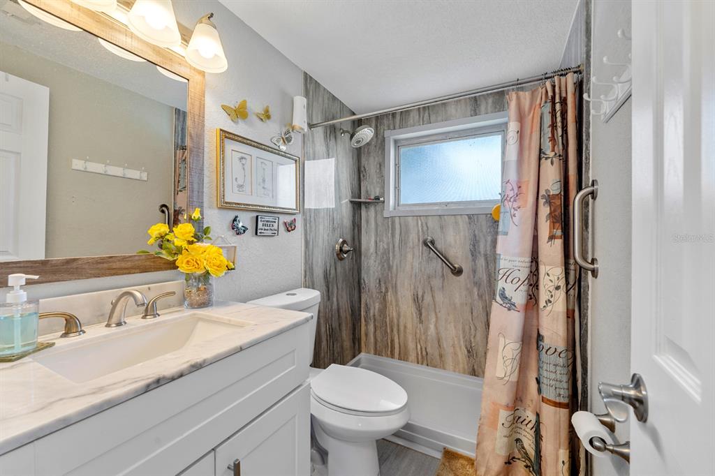 2152 Arcadia Road Holiday, FL 34690 - Photo 18 of 30 a bathroom with a granite countertop sink toilet and shower