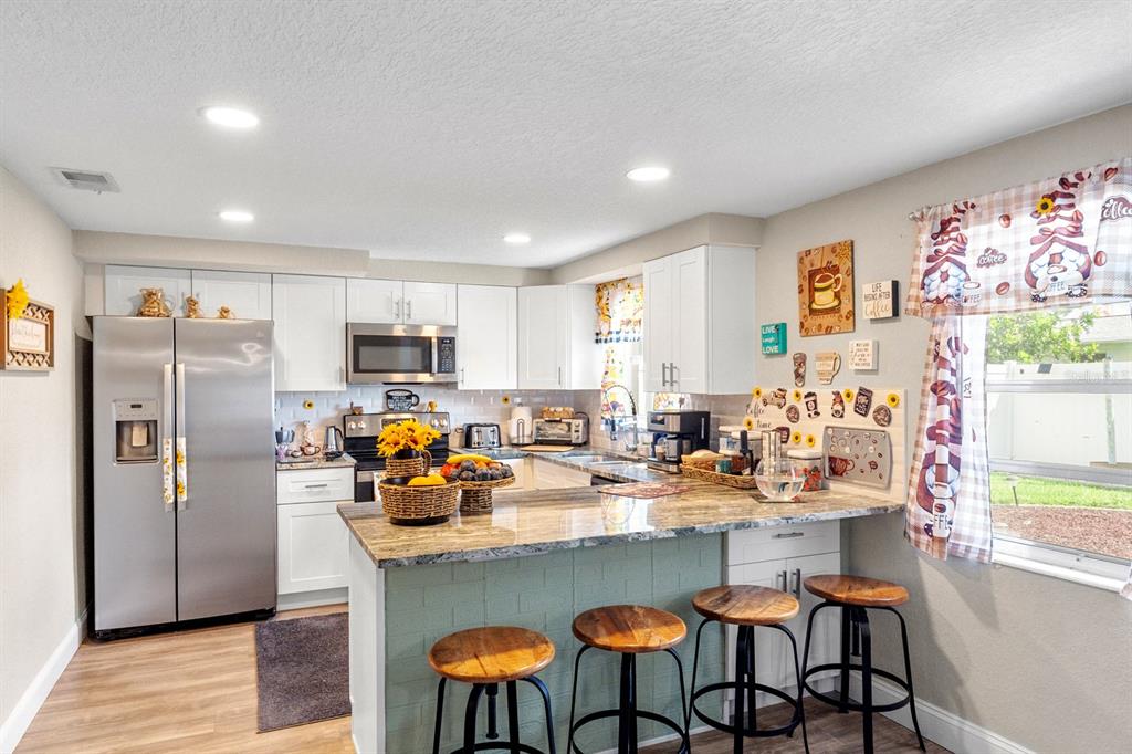 2152 Arcadia Road Holiday, FL 34690 - Photo 9 of 30 a kitchen with stainless steel appliances granite countertop a refrigerator and a sink