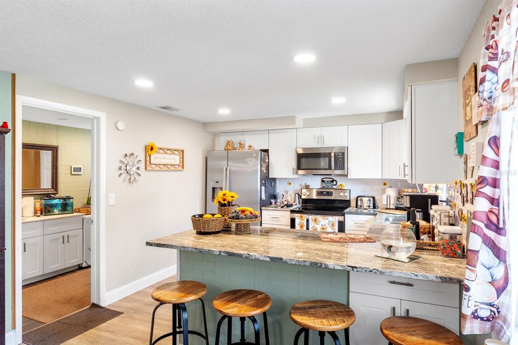 2152 Arcadia Road Holiday, FL 34690 - Photo 10 of 30 a kitchen with stainless steel appliances granite countertop a sink and cabinets