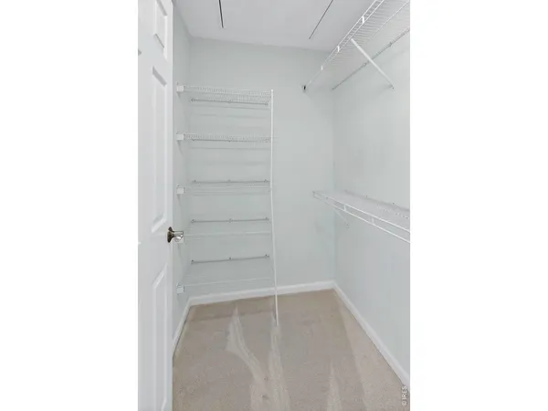 a view of walk in closet with empty racks