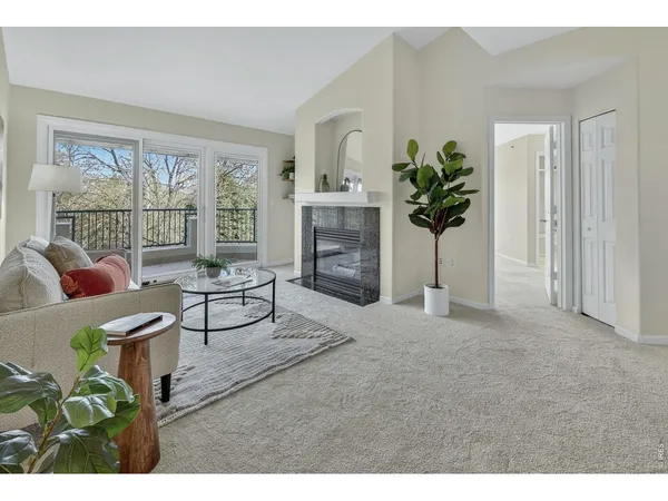 a living room with furniture a fireplace and a potted plant