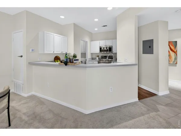 a kitchen with stainless steel appliances a sink a stove a refrigerator a sink a counter top space and cabinets