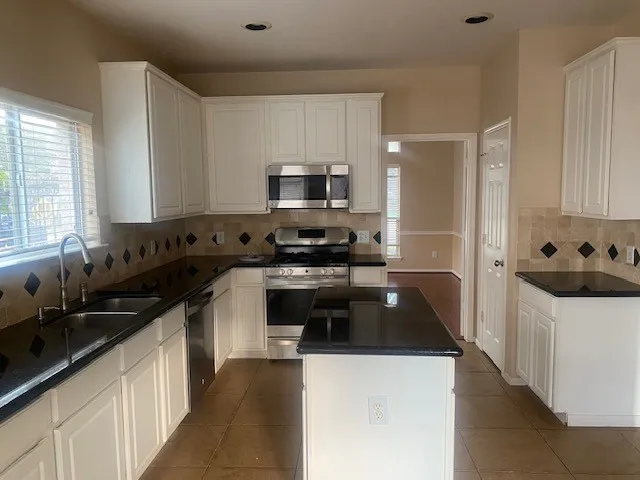 a kitchen with a sink a stove and cabinets