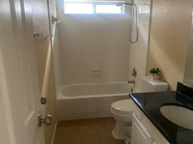 a bathroom with a granite countertop toilet sink and shower