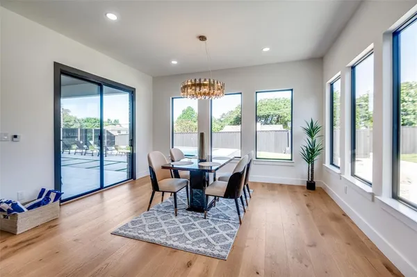 a dining room with wooden floor and glass door