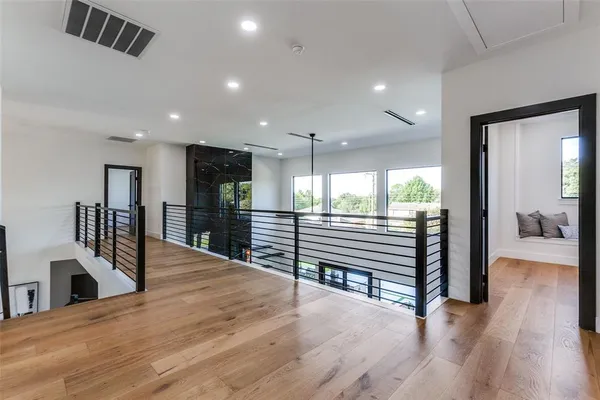 a view of a hallway with wooden floor and furniture