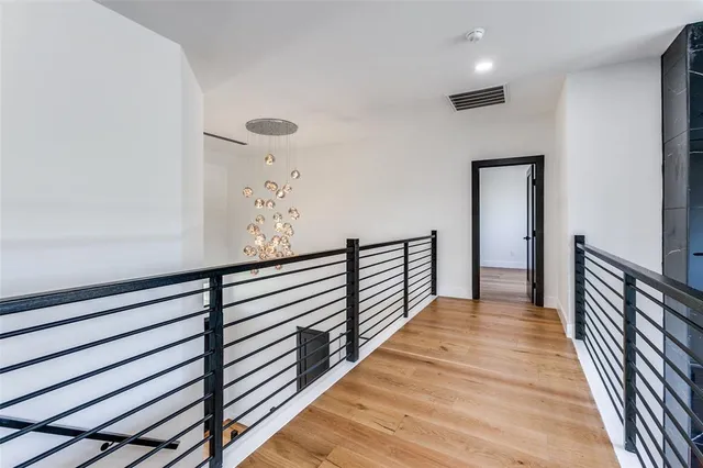 a view of a hallway with wooden floor and stairs