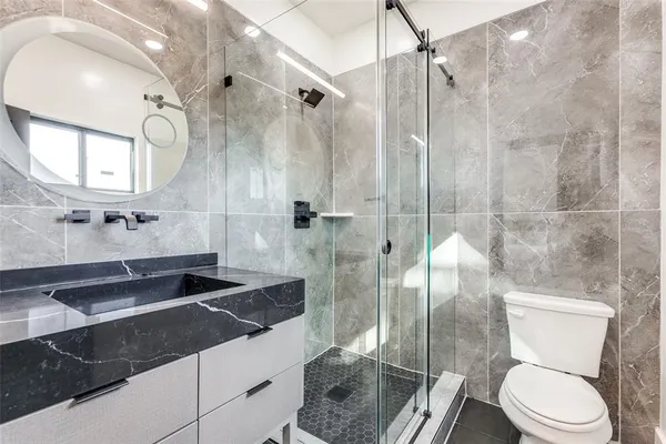a bathroom with a granite countertop sink toilet and shower