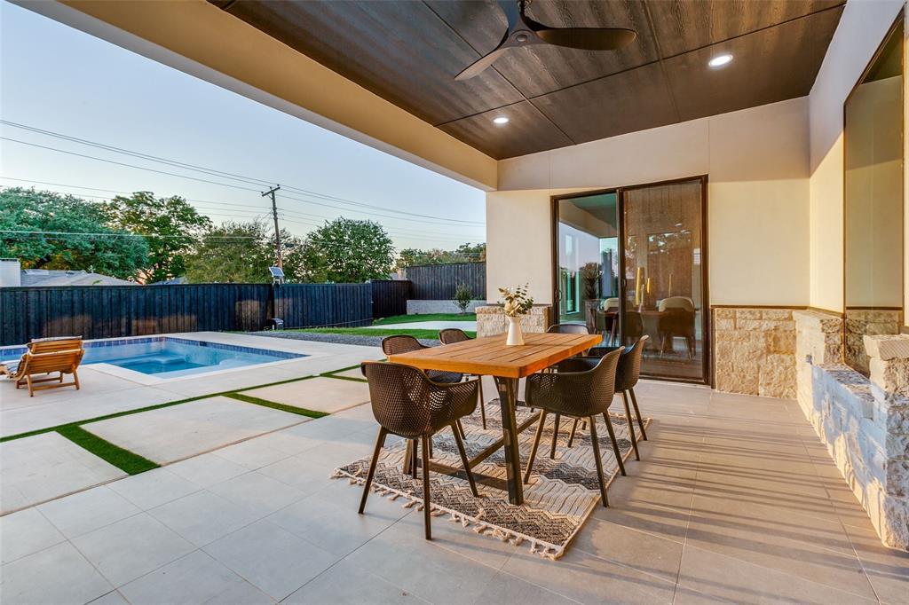 10923 Marsh Lane Dallas, TX 75229 - Photo 36 of 40 a view of a patio with a dining table and chairs with wooden floor and fence
