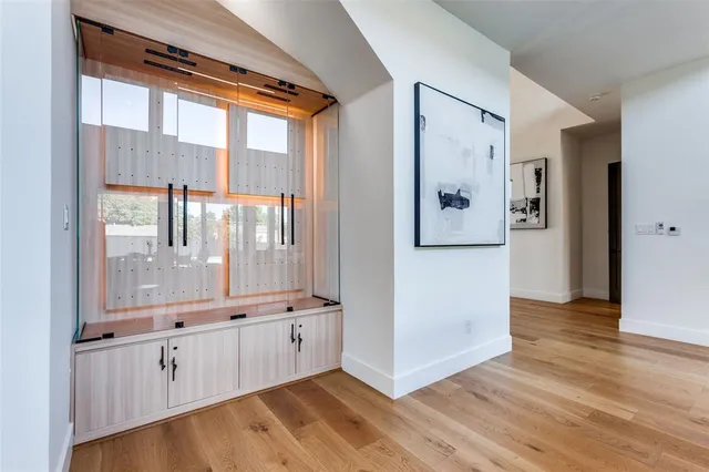 a large white kitchen with granite countertop a refrigerator and white cabinets