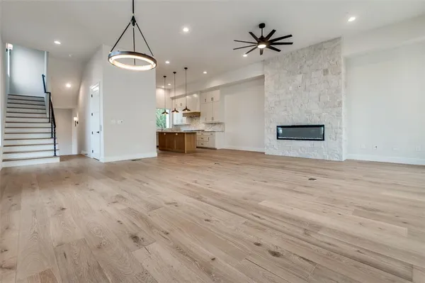 a kitchen with a sink stove cabinets and wooden floor