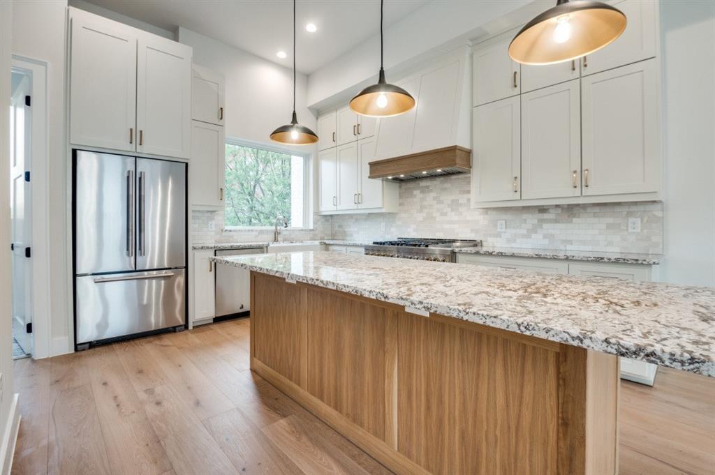 250 East Dallas Road, Unit 121 Grapevine, TX 76051 - Photo 13 of 34 a kitchen with stainless steel appliances granite countertop a refrigerator a sink dishwasher a stove and white cabinets with wooden floor