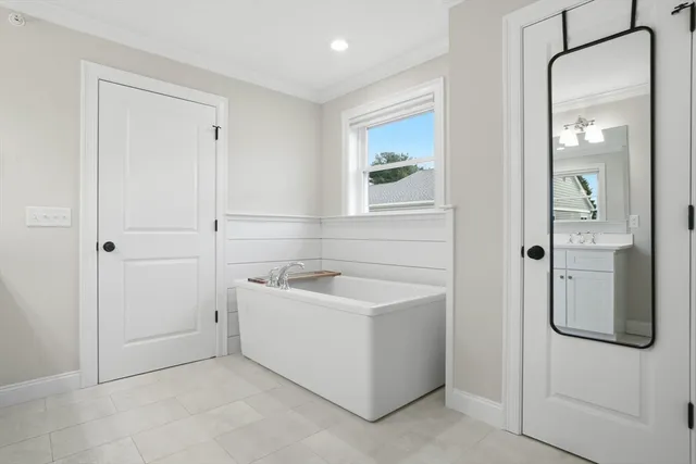 a bathroom with a tub sink and mirror