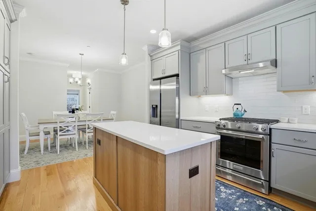 a kitchen that has a sink a stove and chairs