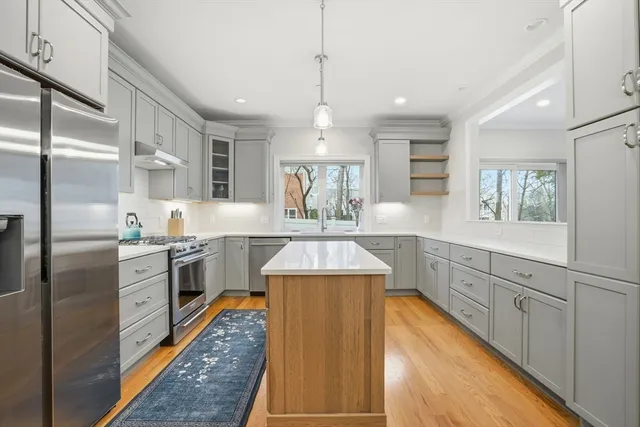 a kitchen with stainless steel appliances granite countertop a sink stove and refrigerator
