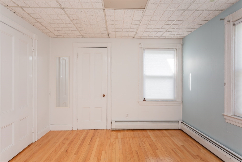 724 High Street Fall River, MA 02720 - Photo 22 of 39 a view of an empty room with wooden floor and a window