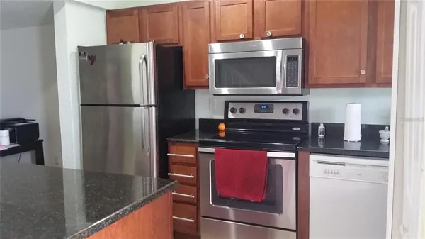 a kitchen with stainless steel appliances granite countertop a refrigerator and a stove