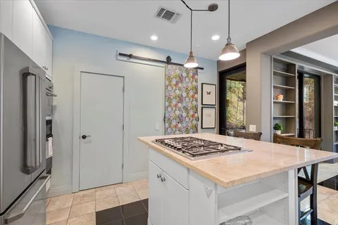 a kitchen view with granite countertop a stove a refrigerator a sink a dining table and chairs