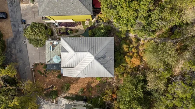 a front view of a house with glass windows and a tree