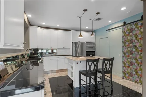 a kitchen with a table chairs microwave and cabinets
